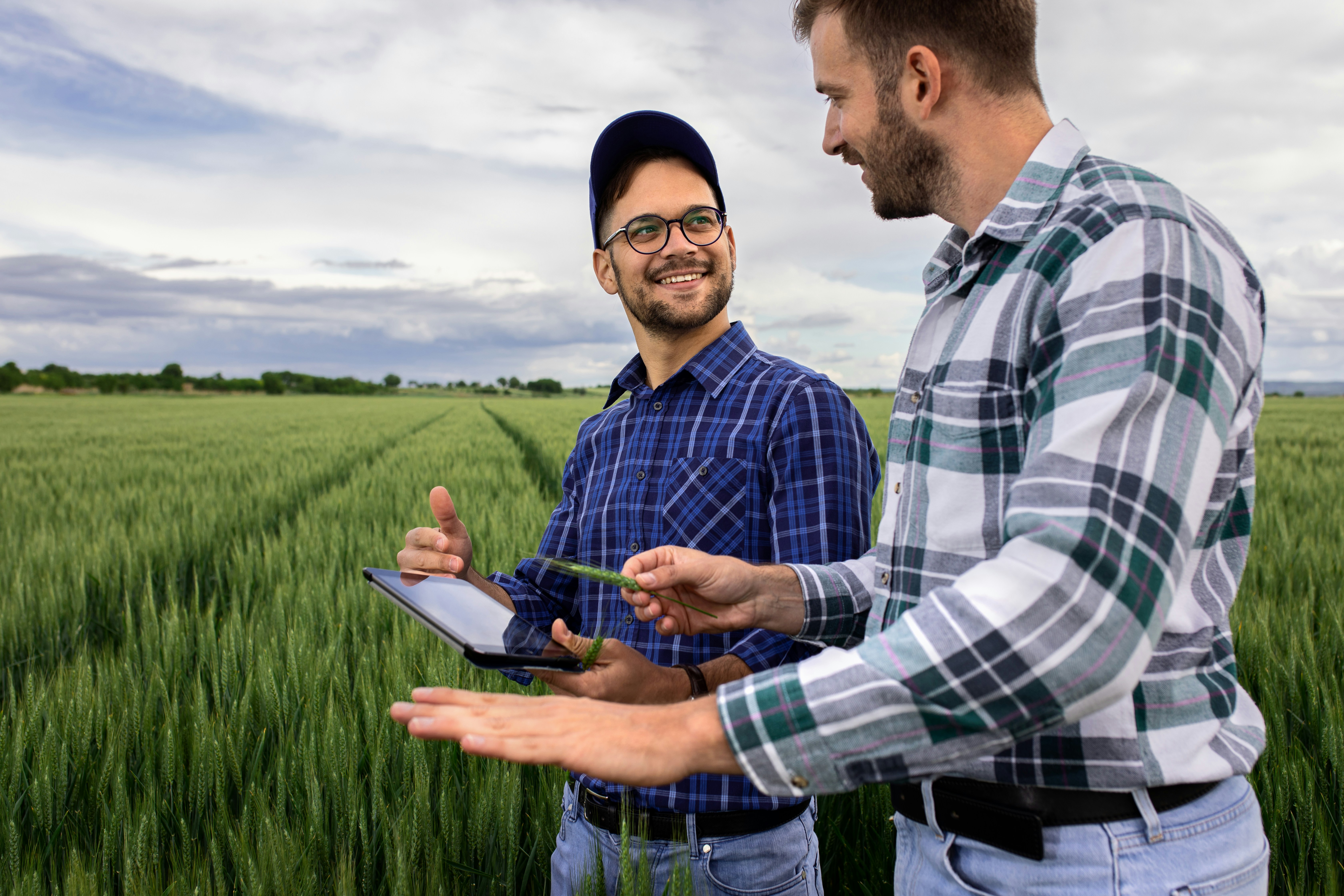 Farmers stand with a clipboard in front of a field