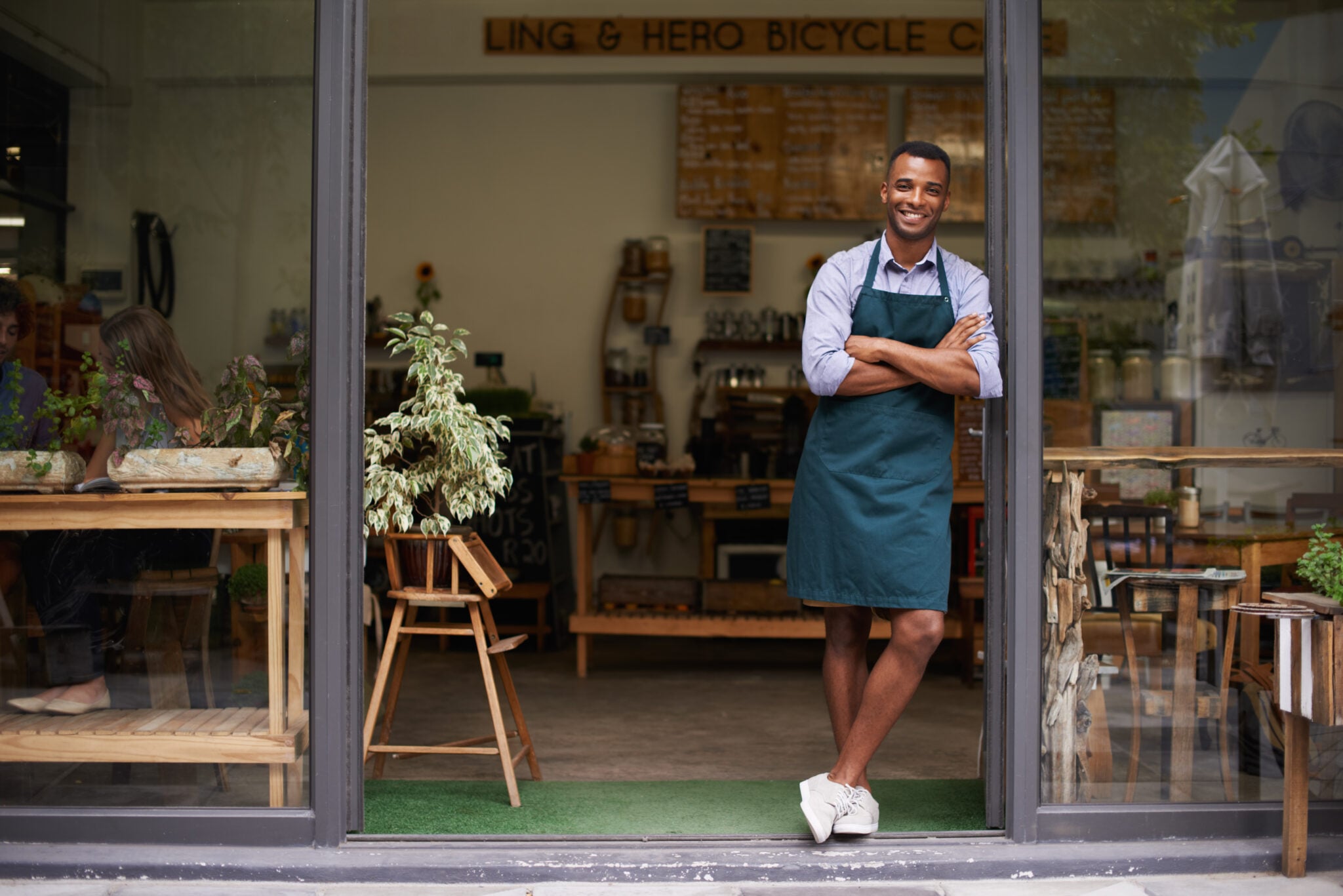 Young man stands at the entrance to his store