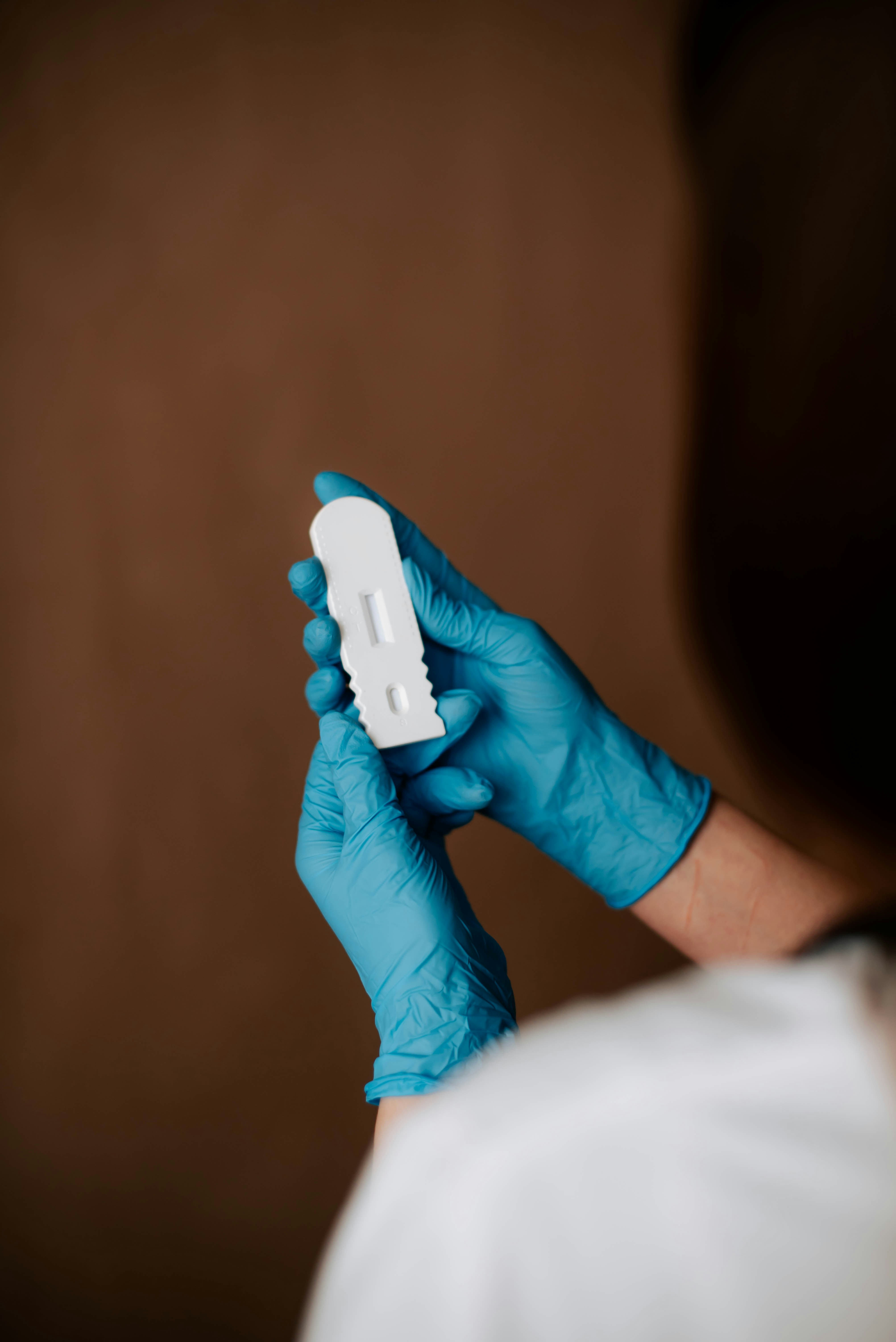kateryna-hliznitsova-GZg18DbLrBE-unsplash A healthcare worker studies a testing kit